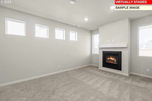 basement with light colored carpet and a wealth of natural light