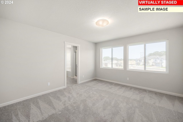 carpeted spare room featuring a textured ceiling