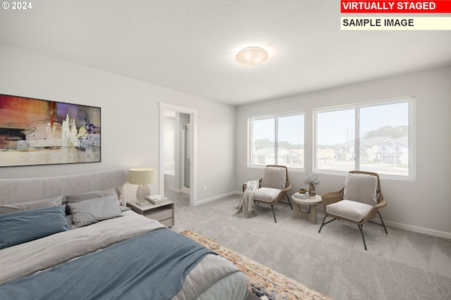 carpeted bedroom with a textured ceiling and ensuite bath