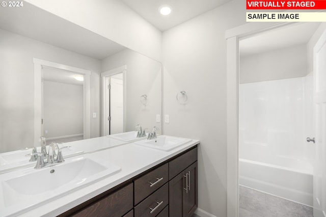 bathroom featuring tile patterned flooring, bathtub / shower combination, and vanity