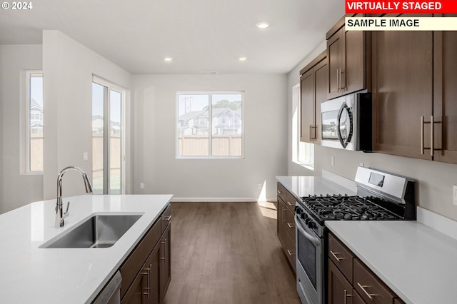 kitchen with dark brown cabinets, sink, dark hardwood / wood-style floors, and appliances with stainless steel finishes