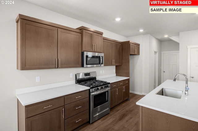 kitchen with dark hardwood / wood-style flooring, sink, and stainless steel appliances