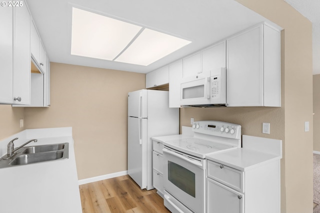 9480 SW 146th Ter Unit Q1, Beaverton, OR 97007 - kitchen with white appliances, a sink, light countertops, light wood finished floors, and white cabinetry
