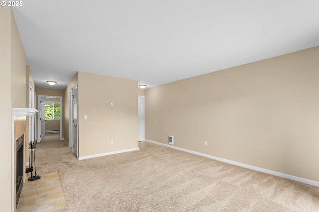 9480 SW 146th Ter Unit Q1, Beaverton, OR 97007 - unfurnished living room with light carpet, baseboards, a tile fireplace, and a baseboard radiator