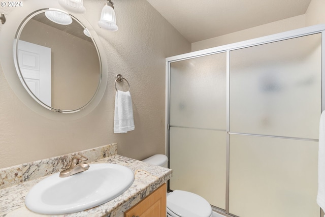 bathroom featuring vanity, toilet, and an enclosed shower