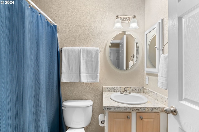 bathroom with vanity, toilet, and walk in shower