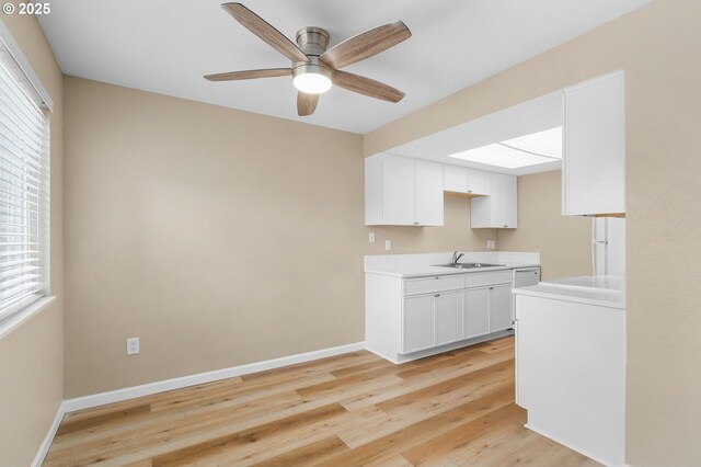 9480 SW 146th Ter Unit Q1, Beaverton, OR 97007 - kitchen with a sink, light countertops, ceiling fan, light wood-style floors, and white cabinetry