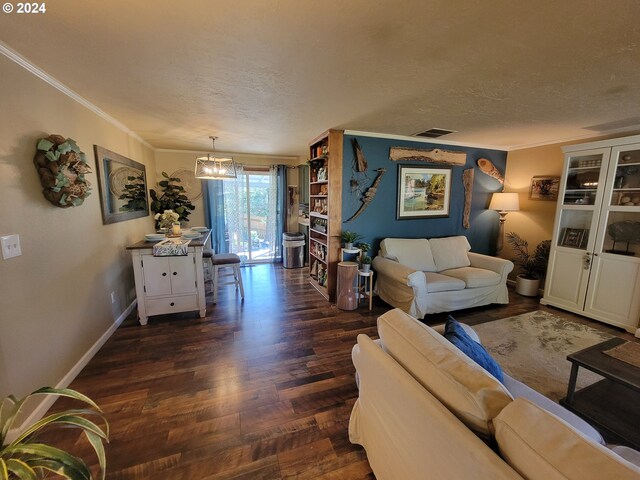 living room featuring an inviting chandelier, a textured ceiling, ornamental molding, and dark hardwood / wood-style flooring