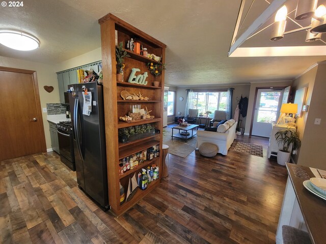 kitchen featuring a textured ceiling, lofted ceiling, dark wood-type flooring, and black appliances