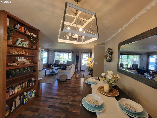 dining room with a textured ceiling, crown molding, dark hardwood / wood-style flooring, and a notable chandelier