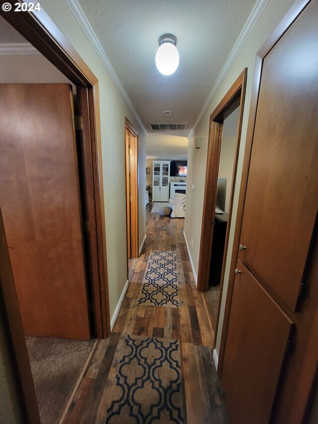 corridor with crown molding and dark wood-type flooring