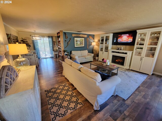 living room with a textured ceiling, crown molding, and dark wood-type flooring