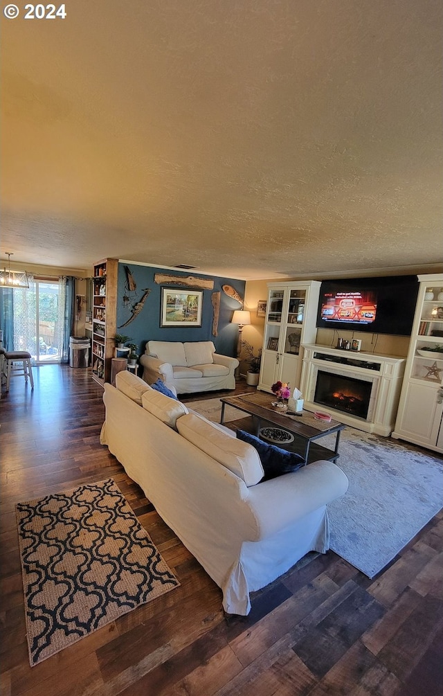 living room with a textured ceiling and dark wood-type flooring