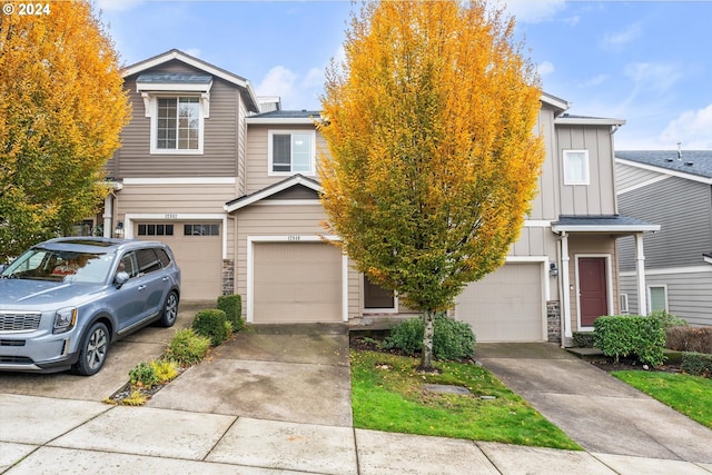 12948 SE 155th Ave, Happy Valley, OR 97086 - townhome / multi-family property with board and batten siding, an attached garage, concrete driveway, and stone siding