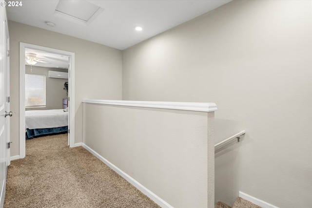 hall with light colored carpet and a wall unit AC