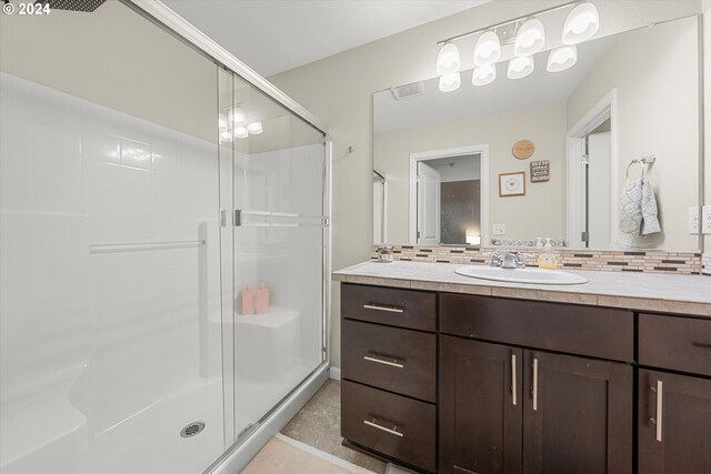 12948 SE 155th Ave, Happy Valley, OR 97086 - bathroom featuring a stall shower, vanity, decorative backsplash, and tile patterned floors