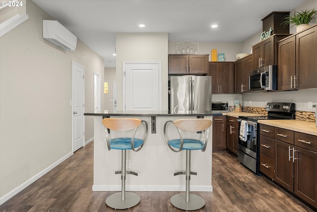 12948 SE 155th Ave, Happy Valley, OR 97086 - kitchen with stainless steel appliances, a wall unit AC, a kitchen bar, dark wood-style flooring, and recessed lighting