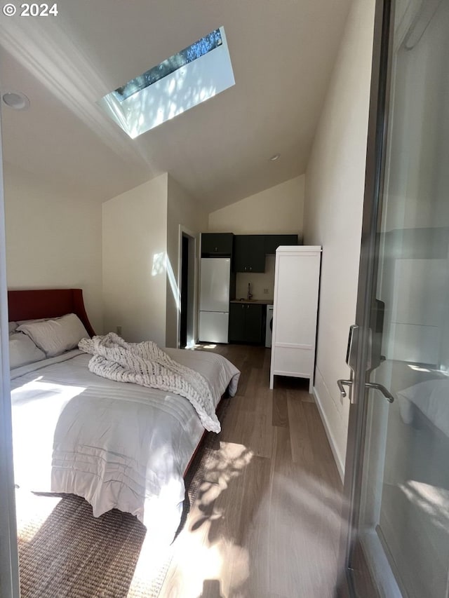 bedroom featuring dark hardwood / wood-style floors, lofted ceiling with skylight, and white fridge