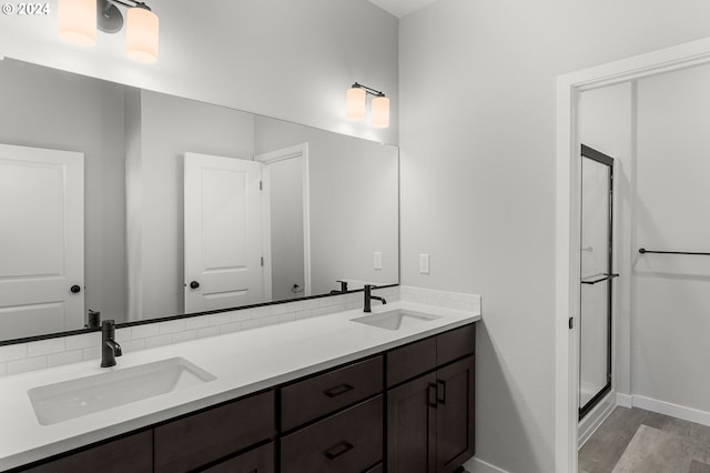 bathroom with hardwood / wood-style floors, vanity, and an enclosed shower