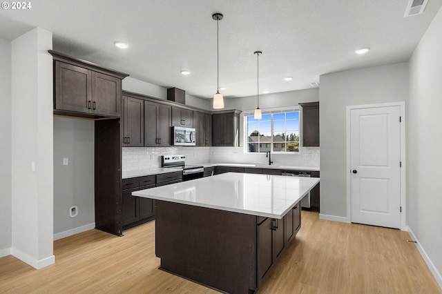 kitchen with tasteful backsplash, a center island, light hardwood / wood-style flooring, and appliances with stainless steel finishes