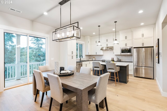 dining area with light hardwood / wood-style flooring and sink