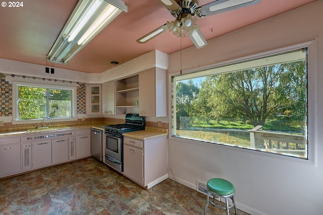 kitchen with ceiling fan, white cabinets, stainless steel appliances, and sink