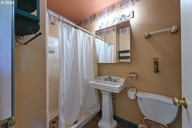 bathroom featuring curtained shower and toilet