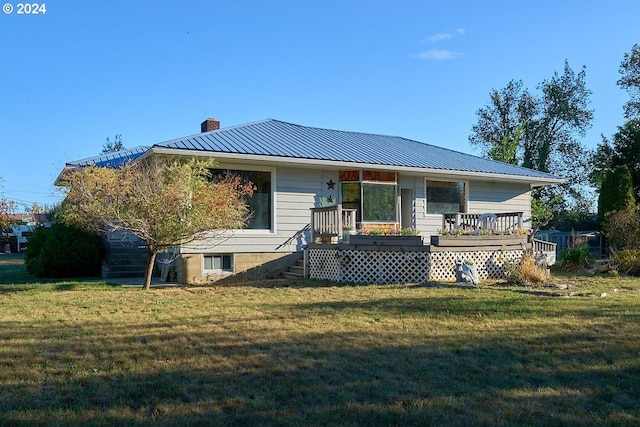 rear view of property with a lawn and a wooden deck