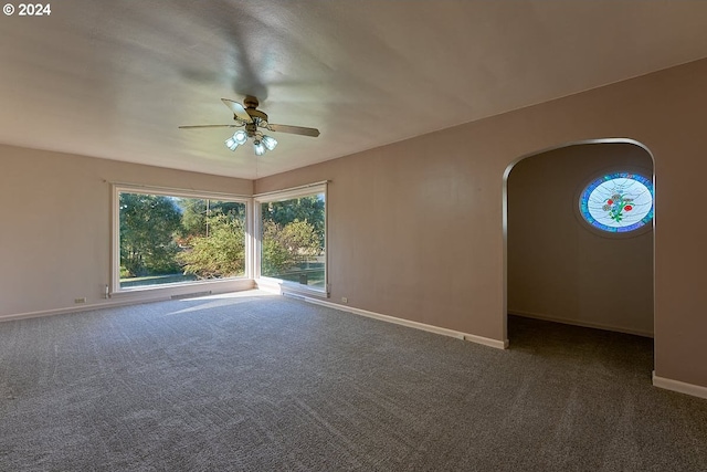 empty room featuring dark carpet and ceiling fan