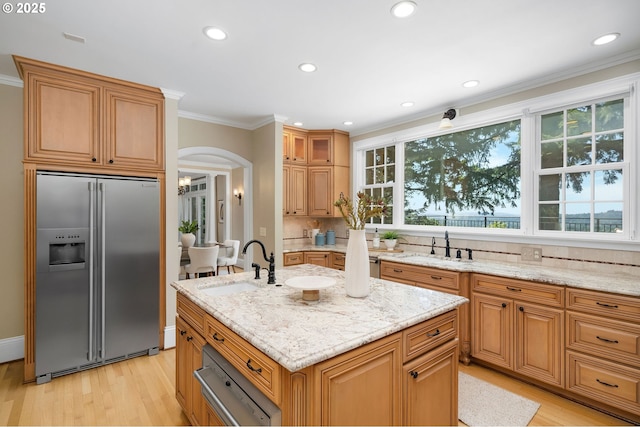 4243 SW Bertha Ave, Portland, OR 97239 - kitchen with stainless steel built in fridge, light wood-style flooring, healthy amount of natural light, light stone counters, and recessed lighting