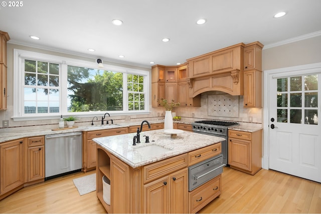 4243 SW Bertha Ave, Portland, OR 97239 - kitchen with appliances with stainless steel finishes, a warming drawer, light wood-style floors, crown molding, and a center island with sink