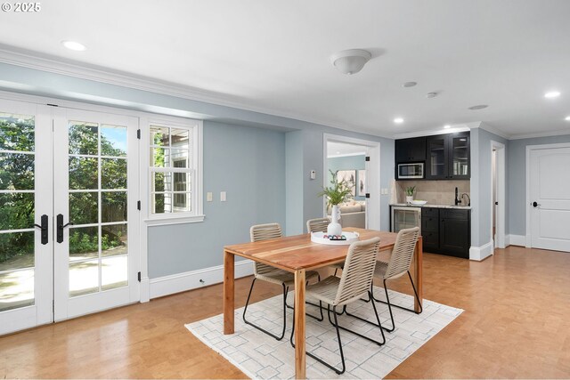 4243 SW Bertha Ave, Portland, OR 97239 - dining room featuring bar with sink, ornamental molding, recessed lighting, light wood-style flooring, and beverage cooler