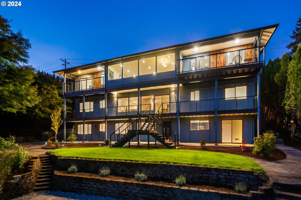 back of property with a balcony and a yard