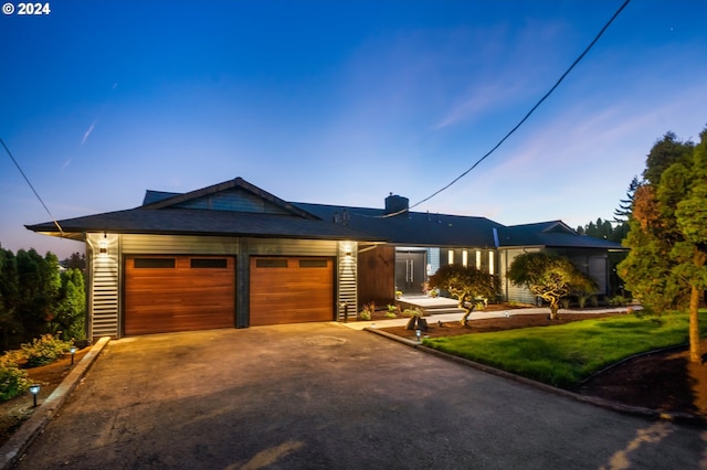 ranch-style house featuring a yard and a garage