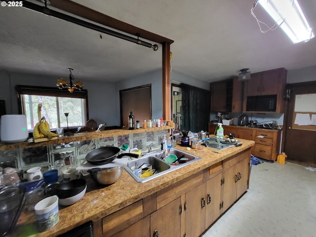 kitchen with stainless steel gas cooktop and a notable chandelier