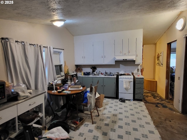 kitchen featuring lofted ceiling, decorative backsplash, a textured ceiling, white cabinetry, and white range with gas cooktop