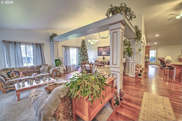 living room featuring wood-type flooring, decorative columns, and a healthy amount of sunlight