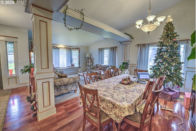 dining room featuring an inviting chandelier, ornate columns, vaulted ceiling, and hardwood / wood-style flooring