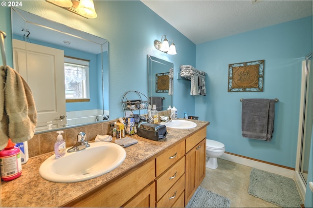 bathroom with vanity, a shower with door, toilet, and a textured ceiling