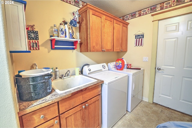 laundry room featuring cabinets, independent washer and dryer, sink, and a textured ceiling