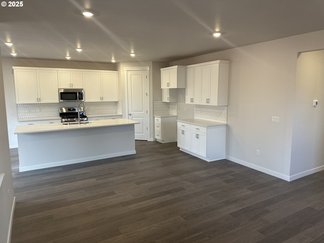 kitchen featuring white cabinetry, stainless steel appliances, and a kitchen island with sink