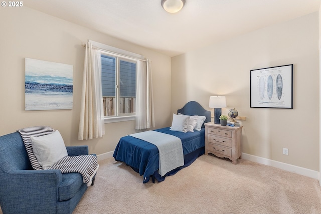 bedroom with baseboards and light colored carpet