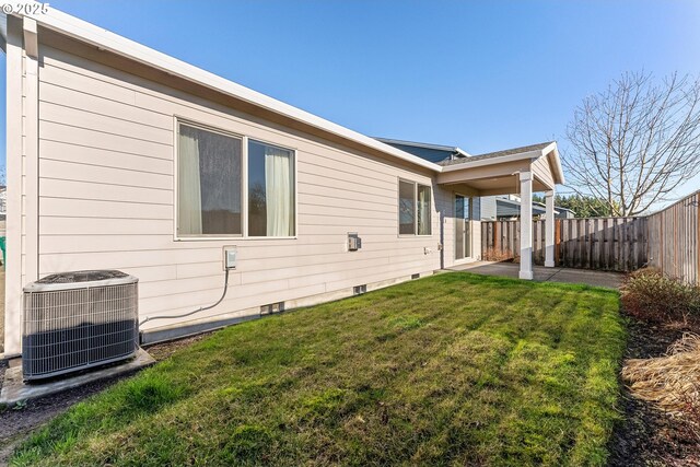 view of property exterior with central AC unit and a lawn