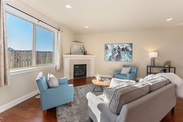 living area featuring dark wood-type flooring, a fireplace, recessed lighting, and baseboards