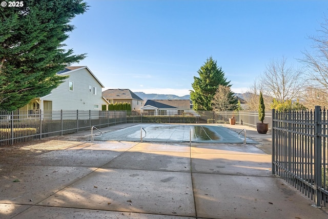 view of pool with a patio, fence, and a mountain view