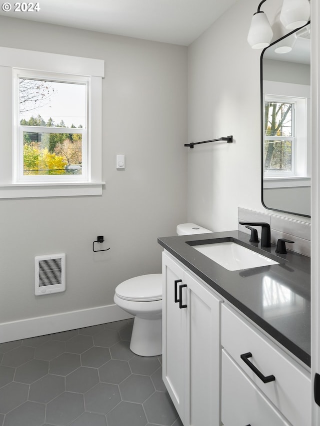 bathroom with toilet, tile floors, and vanity