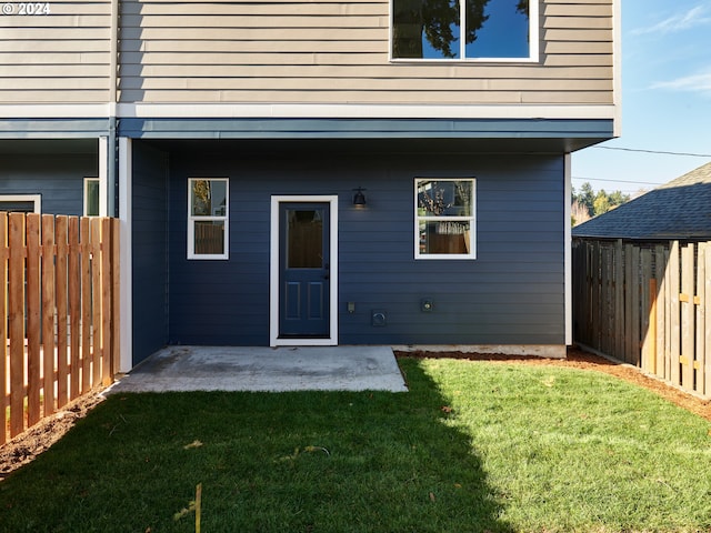 back of property featuring a yard and a patio