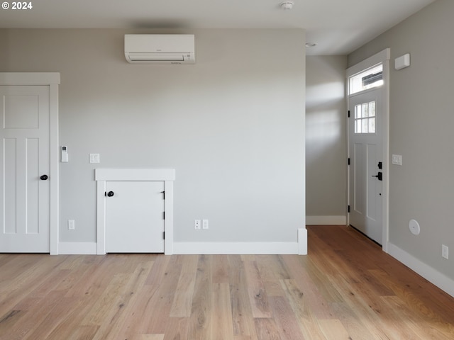 interior space featuring light wood-type flooring and a wall mounted air conditioner