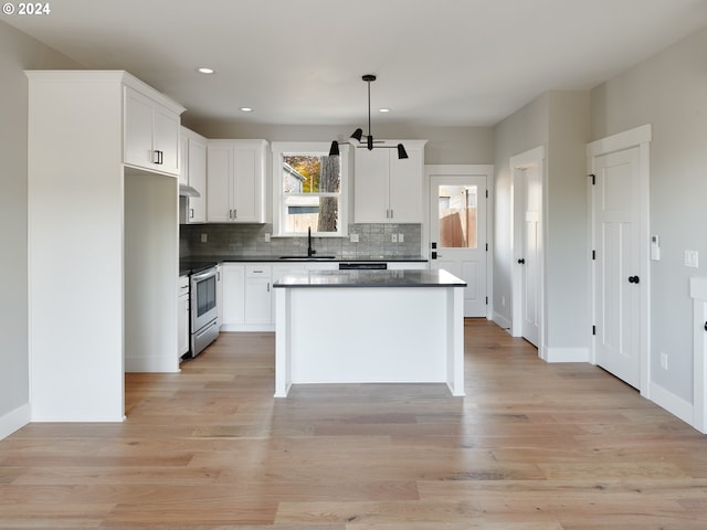 kitchen featuring white cabinetry, electric range, light hardwood / wood-style floors, sink, and pendant lighting