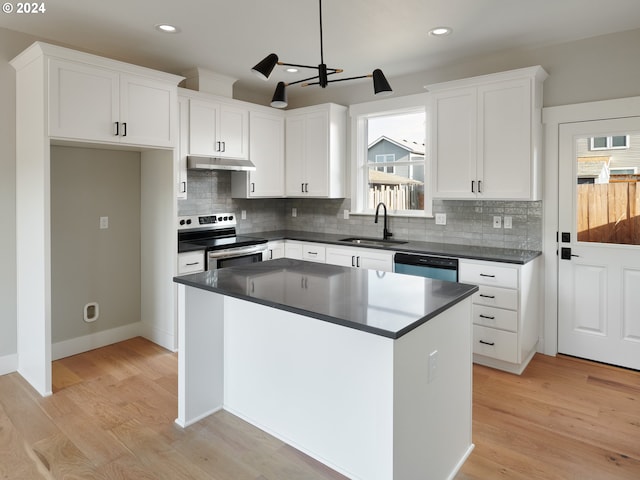 kitchen with stainless steel appliances, light wood-type flooring, white cabinetry, and a wealth of natural light